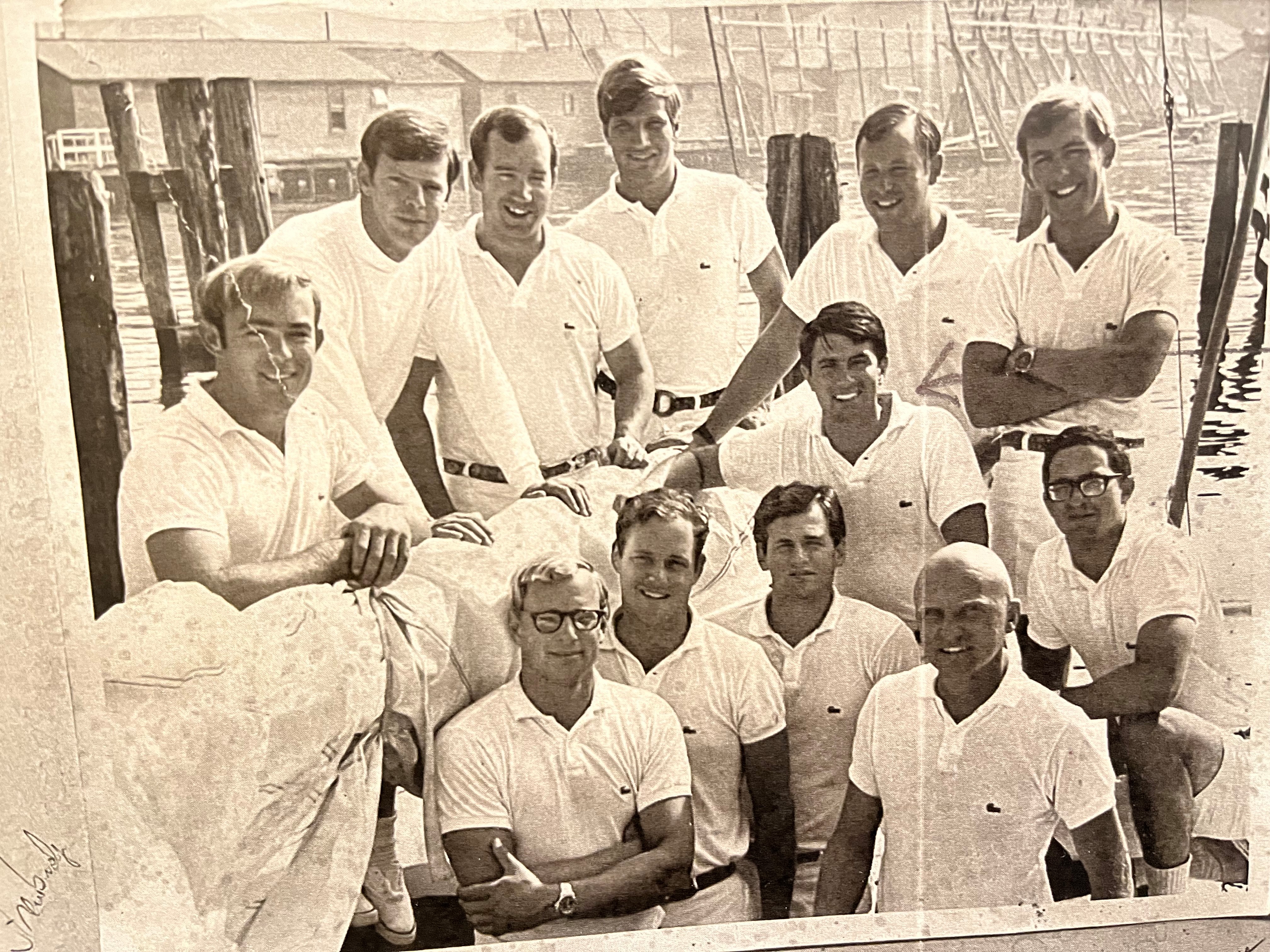 Attorney Richard Sayer (kneeling with right arm on the sail) was a member of the Intrepid crew that defended the America's Cup in 1970. Renown skipper, Bill Flicker, is at bottom right.